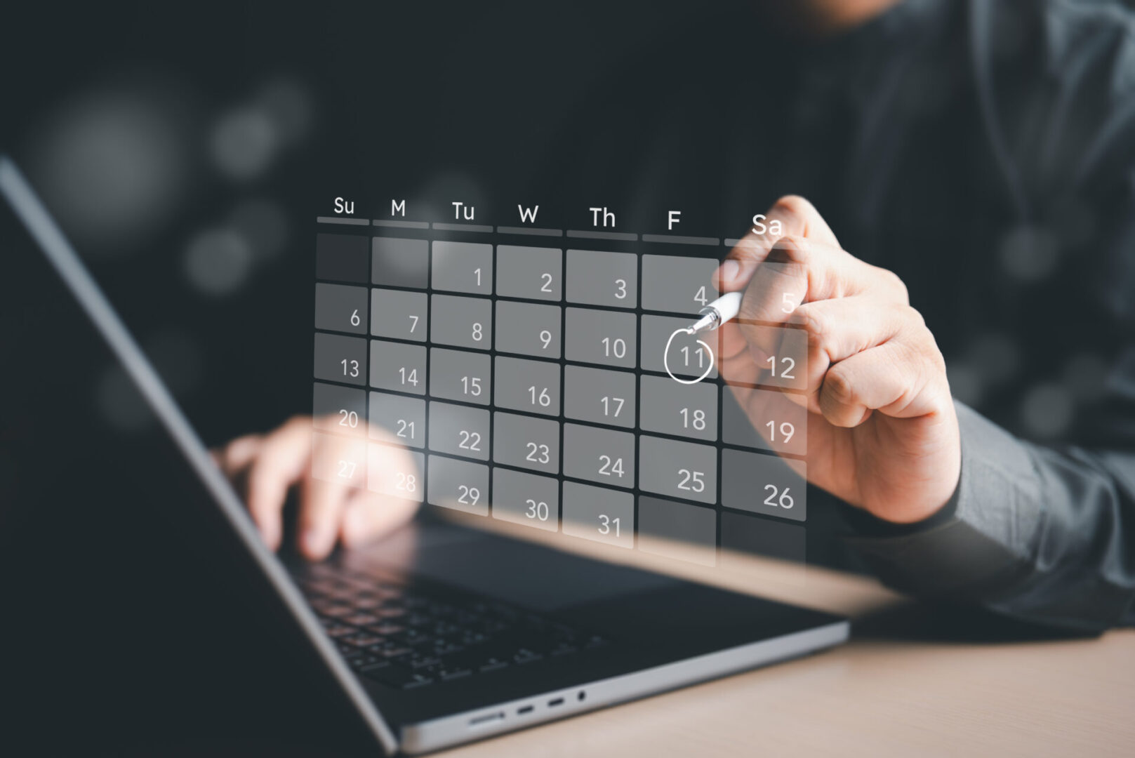 A person is using their laptop to schedule the day.